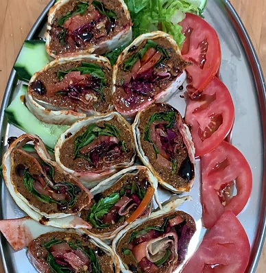 Spicy veggie cig kofte wrap slices on a steel platter